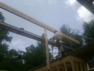 Carpenter setting a ridge beam over a new addition frame — Ice Dam Removal by Roofing Brothers in Hoosick Falls