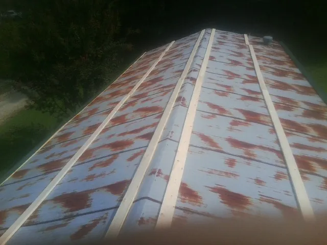 Rusted metal roof panels with new wood purlins before replacement — Storm Damage Roof Repair in Hoosick Falls by Roofing Brothers