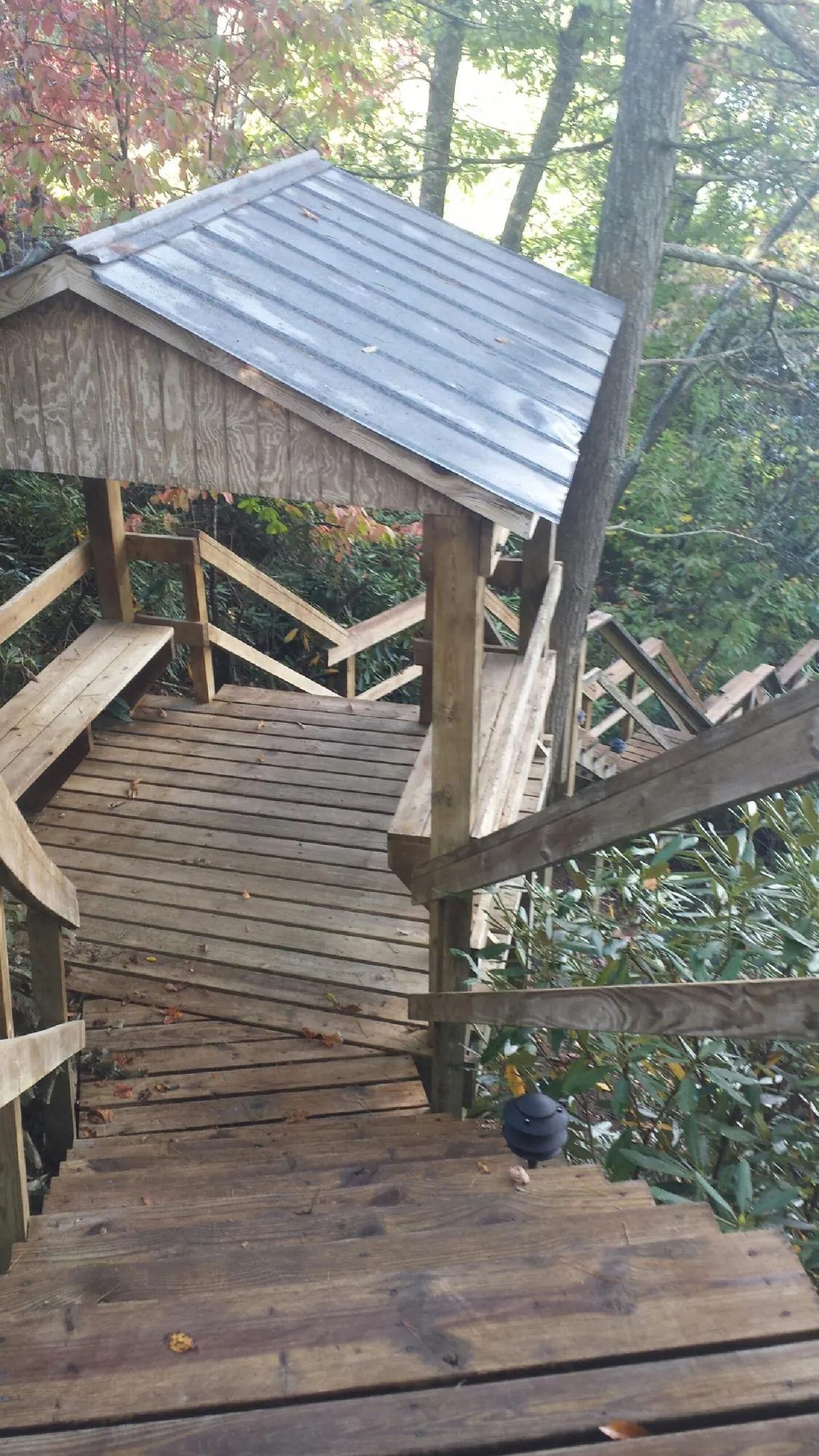 Metal roofed shelter over wooden steps on a wooded walkway — Skylight Repair & Installation work by our crew in Hoosick Falls