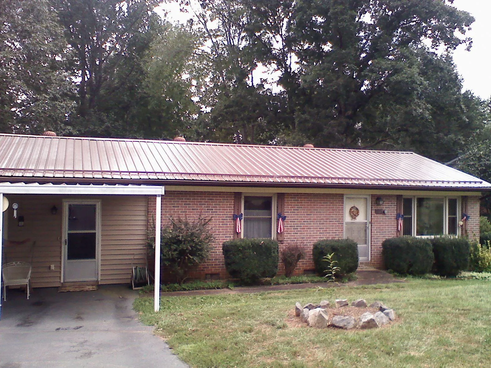 Bronze metal roof and carport on a brick ranch home — Roof Repair work by our crew in Hoosick Falls